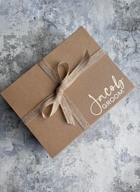 I am so glad you've found my handmade Groom Gift Boxes!  The box will come personalised with the name and role in Gold shimmer & white vinyl to the lid of the box, all ready for you to fill as you wish! 🤍This is for the box only 🤍 Please also see my pre filled 'Big Day Boxes' and 'Bridesmaid Proposal Boxes'  which have been thoughtfully collaborated with your engagement or wedding in mind! 🤍PLEASE ADD YOUR PERSONALISATION REQUESTS INTO THE PERSONALISATION BOX 🤍  Box size: 28 x 22 x 11cm  My