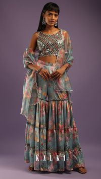 Dusty sky blue sharara and crop top suit in creep with floral print.
The crop top is fabricated in silk with mirror, cut dana and resham embroidered jaal design.
It is crafted sleeveless with cutwork neckline and cut out back with hook closure and tassel dori.
Topped with a matching organza dupatta with floral print and scallop cut border.