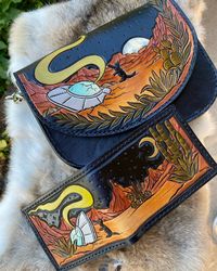 🛸His & Hers🛸 Custom Farewell Transmission mini bag & bifold. We added a playful black cat to this design and I brought back some old tricks with dye. #leather #leatherwork #leatherwallet #leatherpurse #ufo #ufosightingsfootage #desertlife