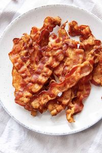 Air Fryer Bacon is extra crispy and so easy to make - no flipping required! Learn how to cook bacon in the air fryer, including the best temperature and cook times. Enjoy this breakfast favorite with eggs, pancakes and more!