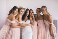 five bridesmaids in pink dresses with bride in white dress toget