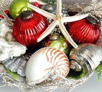 a bold beach Christmas centerpiece of bright vintage Christmas ornaments, starfish and seashells is a pretty idea you can easily realize