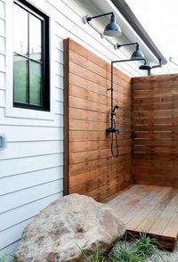 For this backyard retreat, deep bowl lighting brightens an outdoor shower!