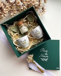 Um gesto especial para quem faz parte do seu grande dia! 💚 Nosso kit personalizado é a escolha perfeita para noivos que querem surpreender seus pais, padrinhos, madrinhas e amigos. Cada detalhe foi pensado para marcar esse momento único: uma caixa de MDF em verde esmeralda, duas xícaras de porcelana com nome e uma mini vela aromática. 💍💚 Tudo personalizado à mão para dar um toque artístico e deliciado. 🌿 Garanta o seu e espalhe carinho no seu casamento!💖 . . . . . #casamentodossonhos #prese...