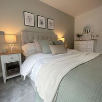 This bedroom boasts soft greens and natural colours to create a fresh yet modern atmosphere. A beautiful upholstered bed contrasts effortlessly with the white and washed oak furniture completing the room.