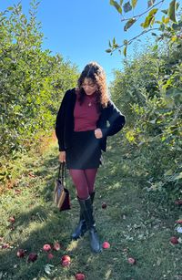 Wondering how to style your knee high boots for fall? Try pairing them with a trending fall color! Create this burgundy outfit by pairing burgundy tights, a mini skirt, burgundy top, cardigan, and burgundy bag. 