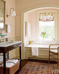 bathroom with antique table as sink vanity, Caucasian rug and antique bamboo chair {towel storage idea}