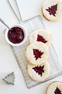 This is a great linzer cookie recipe for Christmas! The raspberry jam filling is perfect for keeping things festive! #cookies #holidaybaking #christmasbaking #pinacooks #linzercookies