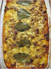 Bobotie is a classic South African dish of  gently-spiced ground meat full of raisins which is then oven-baked with a layer of savory egg custard on top to form a crust and keep the meat moist. Tradionally it is served with Yellow Rice. ♥ Cook Sisters!