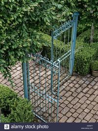 Blue wrought iron gates at garden entrance with cobbled path and box Stock Photo, Royalty Free Image: 111370231 - Alamy