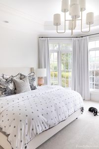 Blush bedroom lamps on nightstand next to upholstered bed