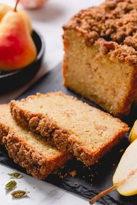 Closeup shot of pear bread slices on black cutting board.