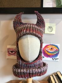 Purple striped balaclava with horns, made by hand with acrylic and wool yarn.