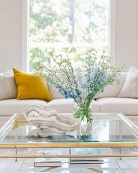 White sofa with gilded, glass top coffee table, yellow pillow, onyx bowl | Designer: Carla Aston, Contractor: Shaun Bain, Photographer: Colleen Scott #living room #livingroomideas #whitesofa #yellowpillow #coffeetable #coffeetablestyling