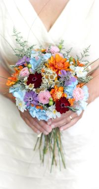 "The Colorful Wildflower Collection | Bridal Bouquet  This preserved flower bouquet boasts bright and bold hues of tangerine orange, dusty blue, lavender purple, plum purple and subtle touches of white. It is accented with untamed greenery. It makes for a colorful addition to a spring, summer or fall wedding. This handmade bouquet is made with 100% real dried and preserved flowers, foliage as well as handmade flowers (the orange zinnias). This is a great alternative to silk flowers as well as fr