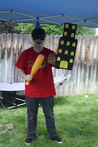 My little brother volunteering to finish off the tower pinata dressed with Godzilla hat.