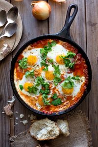 Shakshuka may be at the apex of eggs-for-dinner recipes, though in Israel it is breakfast food, a bright, spicy start to the day with a pile of pita or challah served on the side. (It also makes excellent brunch or lunch food.) It’s a one-skillet recipe of eggs baked in a tomato-red pepper sauce spiced with cumin, paprika and cayenne. (Photo: Andrew Scrivani for The New York Times)