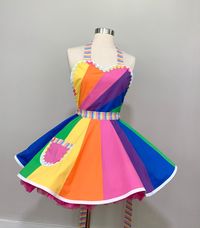 You are a walking (possibly dancing) bright, colorful rainbow in our Color Me A Rainbow Apron!! The bodice is a rainbow design featuring the colors of the rainbow striped waistband and ties- yellow, orange, pink, purple, blue and green. The 16- gore circle skirt doubles down on the rainbow effect and is fully lined. The whole design is very feminine, flirty, and fun! So many twirl days ahead!! The bodice is fully lined. The ranbow striped neck straps are adjustable with a D-ring. Waist ties are