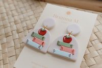 cute little off white speckled polymer clay earrings with stacked books and apple detail