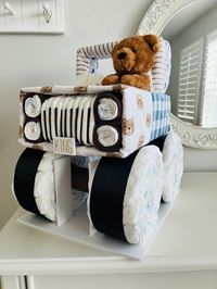 "Vroom, vroom! It's baby's first jeep!!  This diaper jeep features brown and blue colors,  bears, plaid, and mountains! It is a show stopper centerpiece!  This also makes the perfect gift for a teddy bear, adventure awaits, or outdoors/mountain baby shower theme!!  Included: * 90 Huggies Winnie the Pooh Diapers Size 1 * (4) baby blankets teddy bear theme * (1)  9\" teddy bear  * (6) Super soft baby washcloths * Cellophane gift wrap included -- and NO assembly required!  Personalization Optional: Custom name license plate with baby's name Approximate Jeep Dimensions: L: 15\" W: 12\" H: 19\" Other Information:  * Some pins used to hold blankets, please let mama know to be careful when disassembling. It's easiest to disassemble one item at a time. * All diapers and items are 100% useable! * I