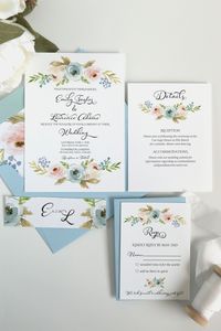 The lovely Harper wedding invitation suite features watercolor florals in dusty blue and blush paired with a light blue envelope. This suite is perfect for a rustic wedding in a garden setting. An elegant script font highlights your names and a monogram belly band provides a romantic touch. #bohowedding #weddinginvitation #rusticwedding