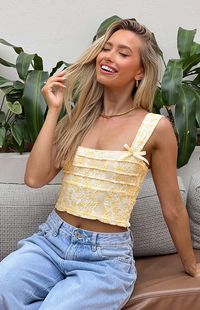 Yellow Lace Crop Top  How to style: This little crop () has the cutest elements including sewn bows on each strap and layered detailing across the front for depth. This top pairs perfectly with white bottoms and chunky jewellery for a Funday Sunday.  Features:     * Light weight lace material   * Slight stretch fabric   * Fully lined   * Thick straps with bow details   * Square neckline   * Invisible left side zip