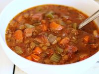 This slow cooker lentil soup features ham, celery, carrots, and onion simmered in a tomatoey broth with basil, oregano, and thyme for a soothing meal.