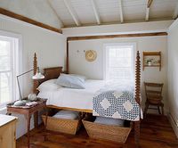 Country Catchalls  Wicker baskets are the storage item of choice in a country home. Two baskets under the antique spindle bed hold extra linens and pillows, so you're always ready for guests. A classic blue-and-white quilt and pillows with blue ticking stripes add color to the simple bedroom.