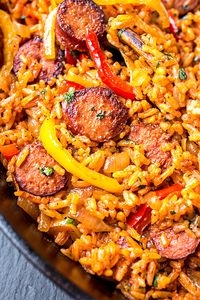 This smoked sausage and red rice skillet is filled with sausage, peppers, and onions, and a hint of tomato—it's the ultimate quick and easy one pan meal! | thecozyapron.com #smokedsausageandredriceskillet #smokedsausage #redrice #skilletmeal #onepanmeal #onepotmeal #ricedish