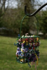 Use a suet feeder to hold scraps of yarn for birds to use in their nests. Great spring project!