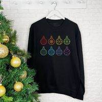 Our Rainbow Christmas jumper will brighten up any christmas occasion. We think that this is a great gay pride Christmas jumper with these rainbow baubles.A great Sweatshirt for Christmas Jumper Day. Multicoloured on a Black Sweatshirt, this Christmas sweatshirt will go with any outfit.We think this is an ideal sweatshirt for all Christmas occasions, wearing to work, drinks at your local German Market, lounging around at home or even on the big day itself. A great alternative to the normal Christmas jumpers out there so ideal to give to a loved one.Hand-printed with love and care by Lovetree Design in our studio in the West Midlands. Every item is quality checked before being dispatched. Items are sent out in packaging that is fully recyclable to be kind to our environment. not given 80% Ri