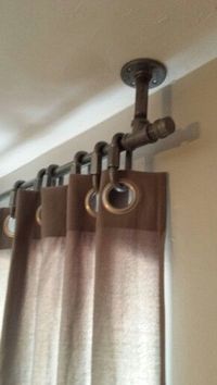 Hang curtains to cover pipes from ceiling cheaper that covering with mock wall