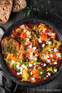 This spaghetti squash breakfast with baked eggs is an easy and healthy meal with tons of flavor. The eggs are nestled into a bold, umami-rich sauce, then topped with feta cheese and parsley. Serve it with buttered toast for one incredible savory meal you can enjoy any time of day! #theendlessmeal #breakfast #spaghettisquash #healthybreakfast #squash