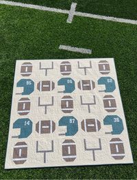 Cheer on your team! With all the available team fabrics and solids, it's easy to customize this quilt for any football fan. Use this quilt to watch the big game, whether on T.V. or on the field. Make this quilt extra special by using the included applique' number templates to personalize the helmets for your favorite player. Traditionally Pieced 72" x 72" Quilt Skilled Beginner Level Pattern Customize to Your Favorite Team & Player Templates for helmet numbers included in pattern YouTube Tutoria