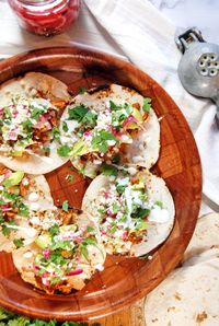 Shredded chicken tacos get kicked up a notch with ancho achiote paste, pickled red onions, avocado, and crema.