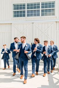 The groom and groomsmen wearing navy blue suits with light blue ties to match the 'something blue' wedding theme at The White Dove Barn in Nashville, TN | John Myers Photography & Videography