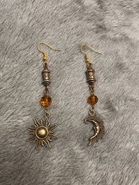 Dangle bronze earrings with a sun and moon charm. Hook is made from hypoallergenic gold plated alloy.