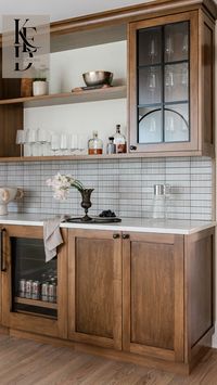 Discover the ultimate in home entertainment with this stylish wet bar setup. Featuring warm wood cabinetry, elegant glass storage, and sleek tile backsplash, this space is perfect for hosting and adds a sophisticated touch to any home. Explore more beautiful design ideas and elevate your home decor with KED Interiors. Perfect for Pinterest users looking for home bar design ideas that blend functionality with aesthetic charm.