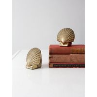 This is a pair of mid-century brass bookends.  Shaped as scallop seashells, the weighted bookends have rounded angles and lovely detailing.  Felt bases to protect your surfaces.