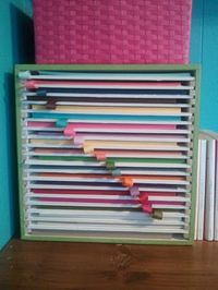 Organize your scrapbook paper by color with this handy cube you make your self from a plain cube from Michael's, 3/8" wood spacers and foam board to create the shelves.