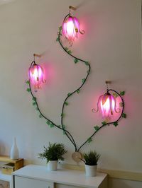 "A beautiful climbing light creation, I have been trying to make a wall lamp with my flower buds for a long time, I finally found the best way to decorate a part of your home with these wonderful colored floral lights and be able to send them far away, it will be very easy to assemble them The lamp is made up of 3 pink and white buds that are very similar but not the same, the true craftsmanship and hand painting make it impossible to have 2 alike.   These buds are made of resin on hand painted