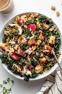 Hearty Autumn Grain Bowls are loaded with fresh, seasonal ingredients for a healthy dinner this fall! Featuring kale, wild rice, quinoa, roasted sweet potatoes, apple, & smoked gouda, it's all finished off with a creamy cinnamon maple balsamic vinaigrette. They're great warm or cold, meal prep-friendly, & easily made vegetarian, vegan, &/or dairy-free. #fallrecipes #healthyfallsalads #grainbowls #fallkalesalad #kalesalad #mealprep #harvestbowl