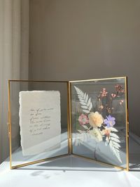 "Custom Calligraphy Double Flower Frame This elegant frame displays one side with handmade paper written with your custom calligraphy. The second side of the frame showcases pressed and dried flowers. This timeless frame makes a beautiful gift, fit for any occasion such as a wedding gift, engagement gift, anniversary gift, Mother's day gift or birthday gift! I would be delighted if you could share your purchase and tag me @oliviangcalligraphy on Instagram 😊 DETAILS -This listing includes vintage brass double frame with handmade paper with your custom calligraphy and pressed flowers  -Size of the frame closed measures 6 x 8\", when the frame is open it is approximately 12 x 16\" -Handmade paper is in an off-white color, measures approximately 4 x 6\"/5x7\" with beautiful deckle edges. For