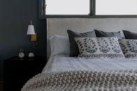 Blues, grays, and plush bedding and pillows. Side table. Bedside lamps. Perfect place to relax.