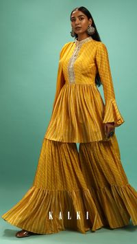 Amber yellow sharara suit in raw silk with bandhani print.
The peplum kurti is adorned with moti, zardosi and stone work on the placket and neckline.
It is crafted with long ruffle sleeves, mandarin collar neckline and side zip closure.
Topped with a chiffon dupatta with bandhani border.