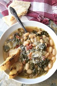 Tomatoes and tender escarole, creamy cannellini beans, and a big punch of garlic combine to create a satisfying soup. And the whole recipe comes together in no time. Learn how to make it now on Foodal. #italianrecipes #beansoup #foodal