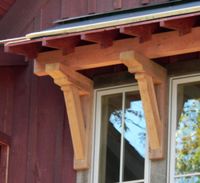 Craftsman-style exterior features: knee braces support a small portico, edged by exposed rafter-tails.