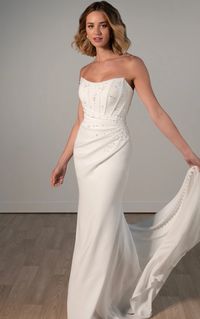 This crepe column dress has a sophisticated scoop neckline side draping and a corset bodice. Try on this Stella York wedding dress at Laura and Leigh Bridal now in New Jersey!