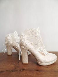 Ivory lace bridal boots will compliment your travel wedding theme beautifully! Pearl enbellished floral lace adds a boho vibe to these elegant wedding shoes. Block heels keep you comfortable all night long. Custom heel heights and custom-fit sizes available on order. #customshoes #bridalboots #weddingshoes #laceshoes #travelwedding