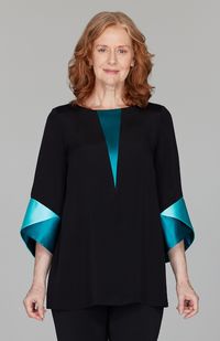 Our signature silk tunic, finished with vibrant color blocked satin cuffs and an added V inset for even more color. An effortless statement piece for any occasion. This is a pullover style with a hook & eye closure at the back neckline.